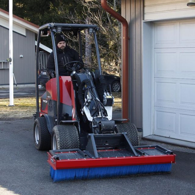 Minilaster utstyrt for gatepuss med børste