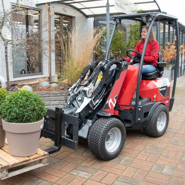 Potteplanter på pall kjøres med minilaster