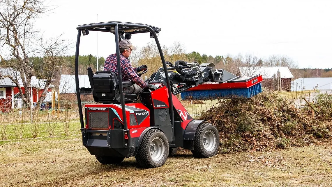 Minilaster i arbeid med vedlikehold av vei